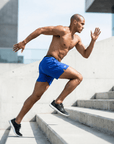 Man wearing flow shorts running up stairs, showcasing active movement and performance.