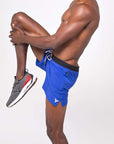 Man wearing lightweight flow shorts in blue during stretch, showcasing moisture-wicking fabric for hot yoga.