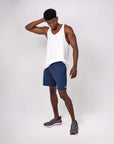 Man in tank top and midnight blue Swerve Shorts showcasing 4-way stretch for optimal movement.