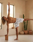 Man performing a yoga pose in Swerve Shorts, Nimbus Cloud, showcasing 4-way stretch fabric and flexibility.