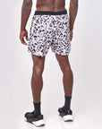 Flow shorts in snow leopard print worn by a model from behind, showcasing moisture-wicking and quick-drying features.