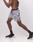Man wearing Flow shorts - Snow Leopard, ideal for hot yoga, showcasing moisture-wicking and quick-drying features.