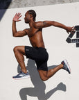Man demonstrating agility in 4-way stretch Swerve Shorts - Crow Black during a workout.
