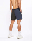 Back view of a male model wearing Flow shorts in blue and black, showcasing comfort and style for active workouts.