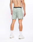 Flow shorts in lichen color showcasing the back view on a model during active movement.