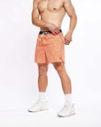 Flow shorts in Desert Orange displayed on a muscular male model, highlighting their moisture-wicking and quick-drying features.