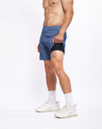 Model wearing 4-way stretch Swerve Shorts in Heather Navy, showcasing comfort and flexibility for active movement.