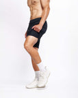 Male model showcasing 4-way stretch Swerve Shorts in Crow Black, designed for optimal movement and performance.